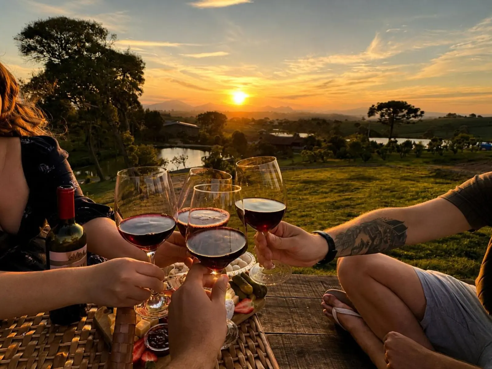 Brinde com vinho ao pôr do sol no sítio